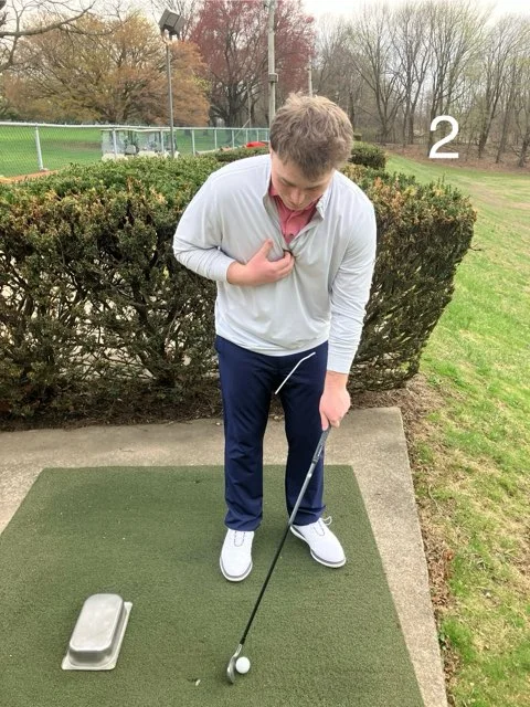 Golfer demonstrating that the hands should sit under the sternum